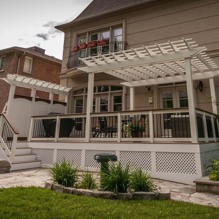 An image of an outdoor covered deck, featuring a hot tub, stainless-steel barbeque and outdoor conversation set.