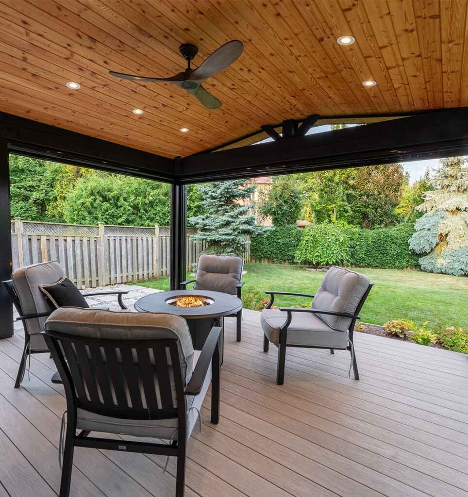 Covered low-maintenance deck with a timber roof, wood ceiling, fan, and easy access from the patio door overlooking the backyard