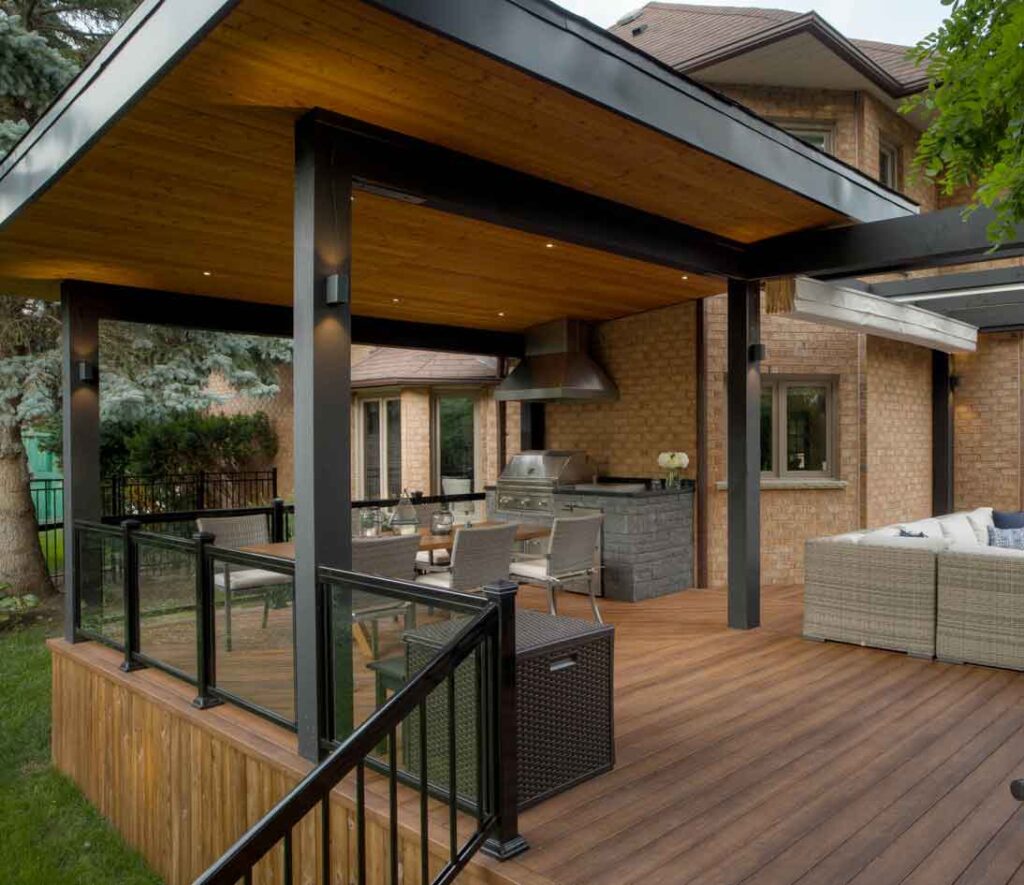 Backyard deck with a modern roof and a dining area underneath for shade and outdoor living