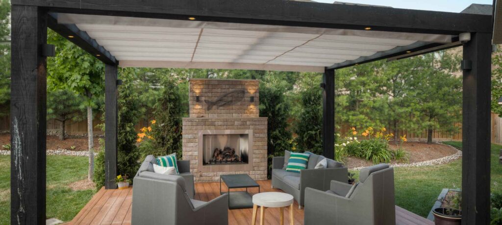 Deck with a timber pergola, retractable awning for shade, and low-voltage lighting for evening use