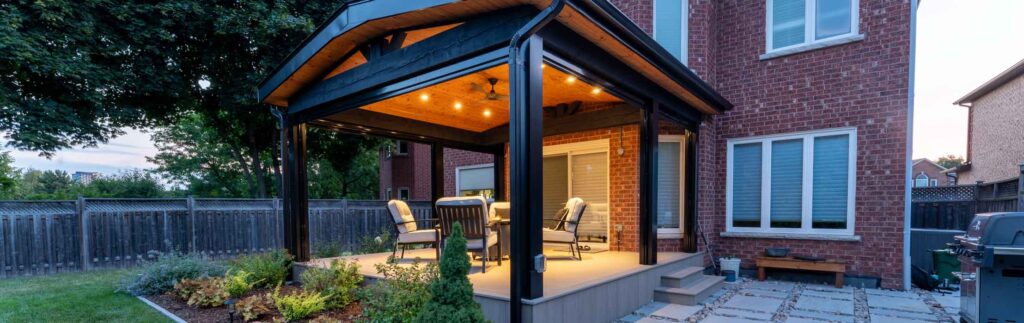 Covered deck attached to a house with lighting and retractable screens for shade