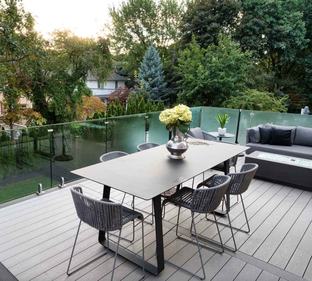 Modern elevated deck with glass railings and low-maintenance materials providing a stunning view from the main floor