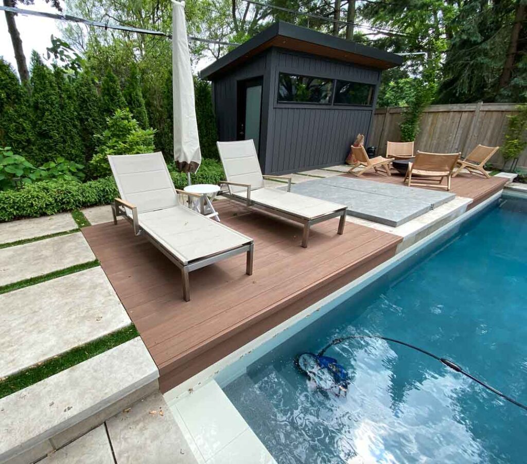 Ground-level deck integrated with stone for a seamless transition, perfect beside the pool for comfortable walking