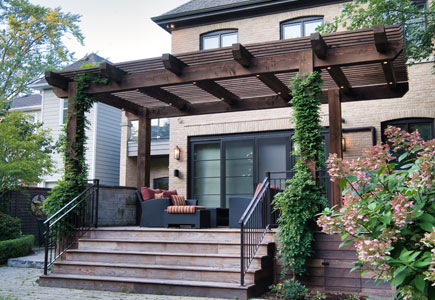 Heat-treated wood deck with timber pergola, wisteria shade, BBQ area, and garden views in Mississauga backyard.