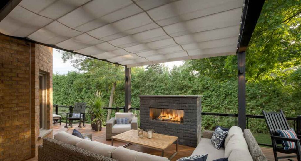 Modern deck with a timber pergola and ShadeFX retractable awning overlooking lush greenery